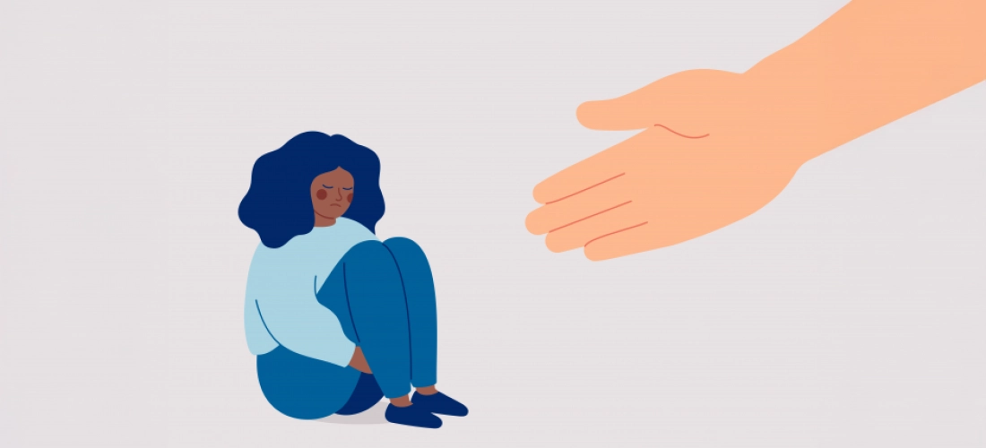 Femme triste assise, main tendue en signe de soutien
